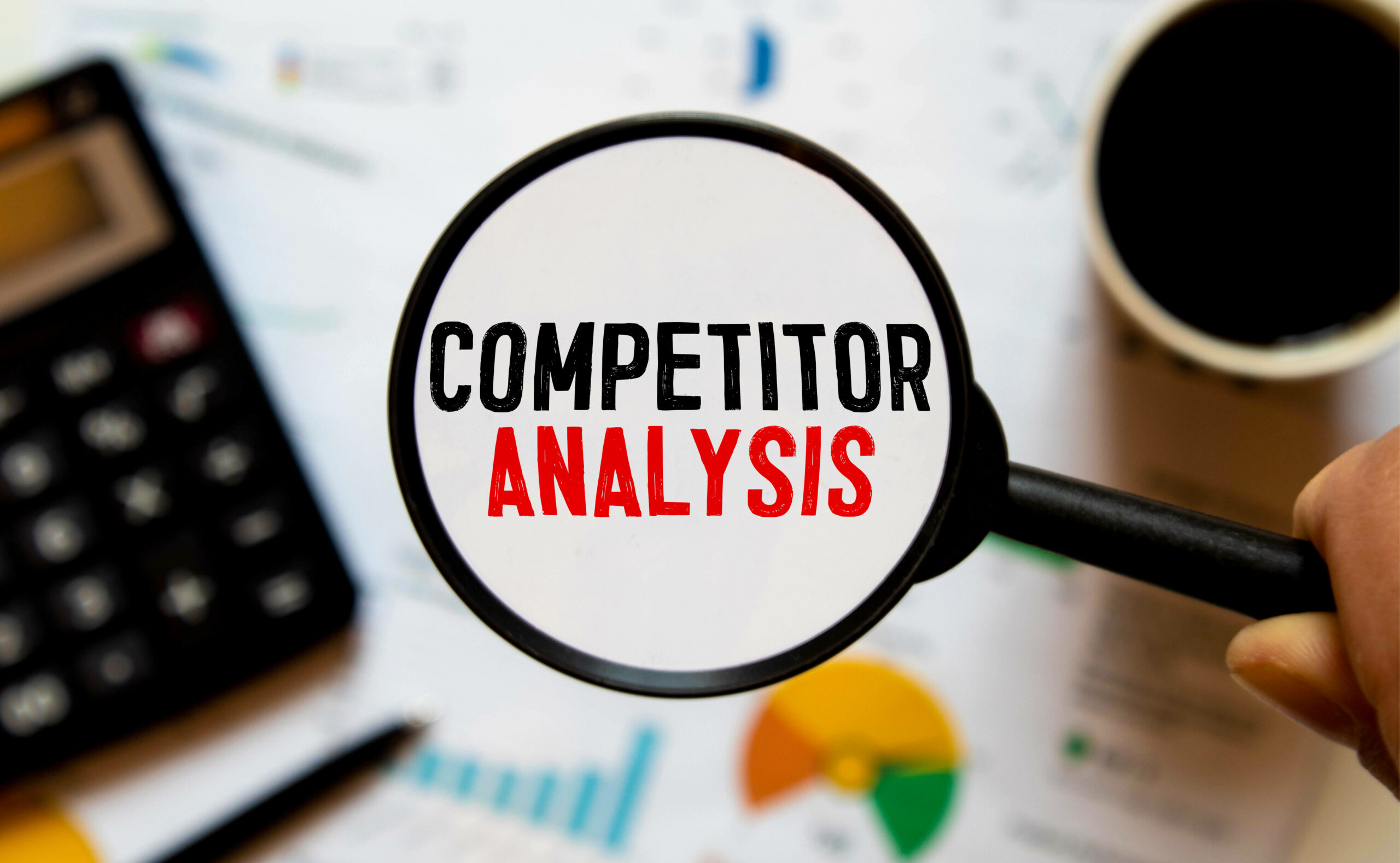 competitor-analysis-word-with-hand-holding-magnifying-glass-jigsaw-puzzle-selective-focus